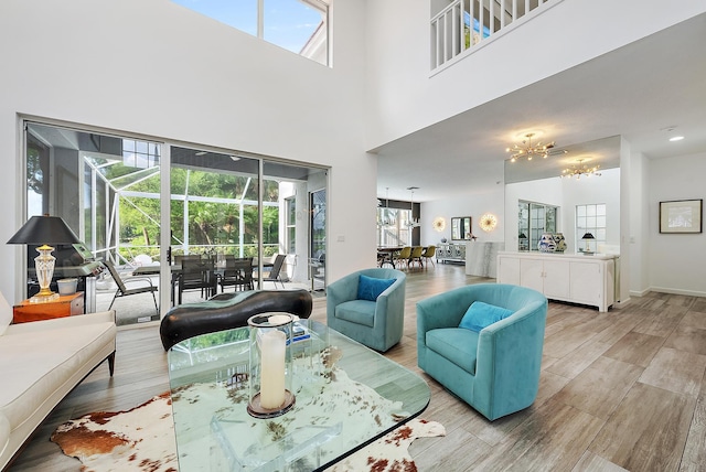 8208 Heritage Club Dr, West Palm Beach, FL 33412 - living area featuring light wood-type flooring, a chandelier, plenty of natural light, and a towering ceiling