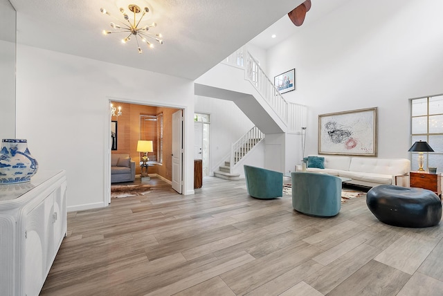 8208 Heritage Club Dr, West Palm Beach, FL 33412 - living room featuring a chandelier, stairway, light wood-style flooring, a towering ceiling, and recessed lighting