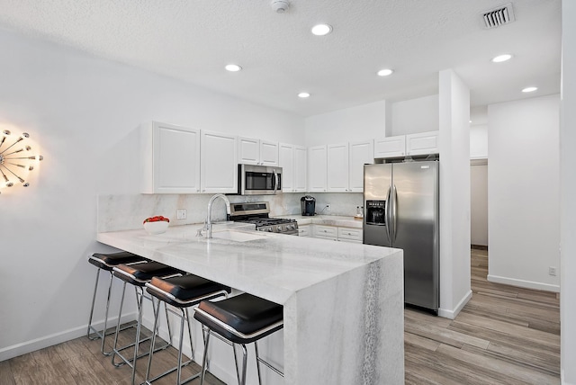 8208 Heritage Club Dr, West Palm Beach, FL 33412 - kitchen featuring appliances with stainless steel finishes, a sink, a peninsula, baseboards, and recessed lighting