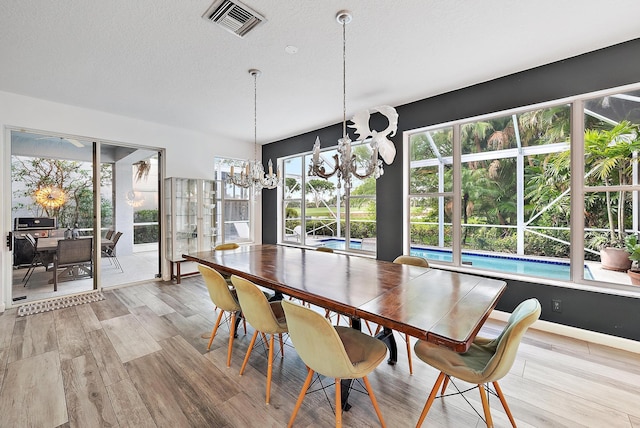 8208 Heritage Club Dr, West Palm Beach, FL 33412 - dining area with a chandelier, wood finished floors, and healthy amount of natural light