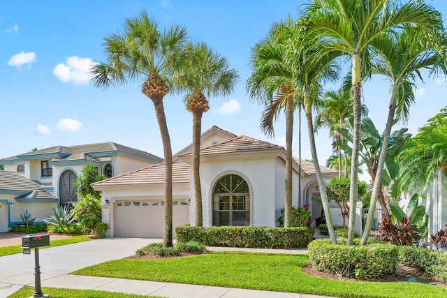 10194 N Lexington Cir, Boynton Beach, FL 33436 - mediterranean / spanish-style home featuring a garage, stucco siding, driveway, a tile roof, and a front lawn