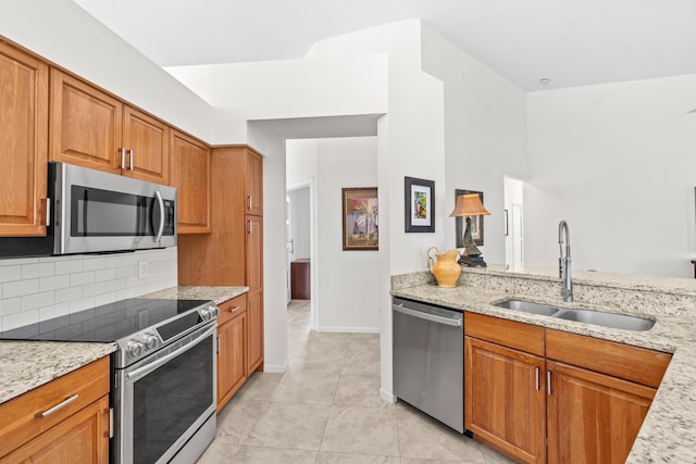 10194 N Lexington Cir, Boynton Beach, FL 33436 - kitchen featuring appliances with stainless steel finishes, a sink, brown cabinets, and light stone countertops