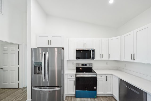 2458 NW 9th Ter, Cape Coral, FL 33993 - kitchen featuring appliances with stainless steel finishes, light wood-style floors, white cabinets, light countertops, and high vaulted ceiling