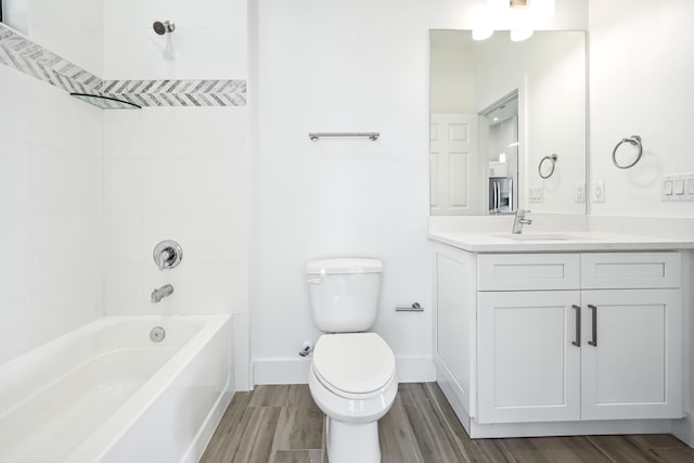 2458 NW 9th Ter, Cape Coral, FL 33993 - bathroom with vanity, toilet, wood finished floors, bathing tub / shower combination, and baseboards