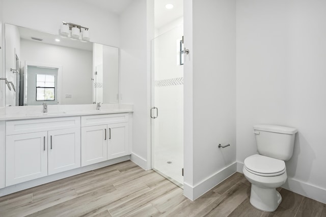 2458 NW 9th Ter, Cape Coral, FL 33993 - full bathroom with wood finished floors, a shower stall, double vanity, toilet, and baseboards