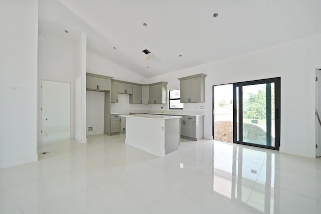 2458 NW 9th Ter, Cape Coral, FL 33993 - kitchen with gray cabinetry, lofted ceiling, a center island, and light marble finish floors