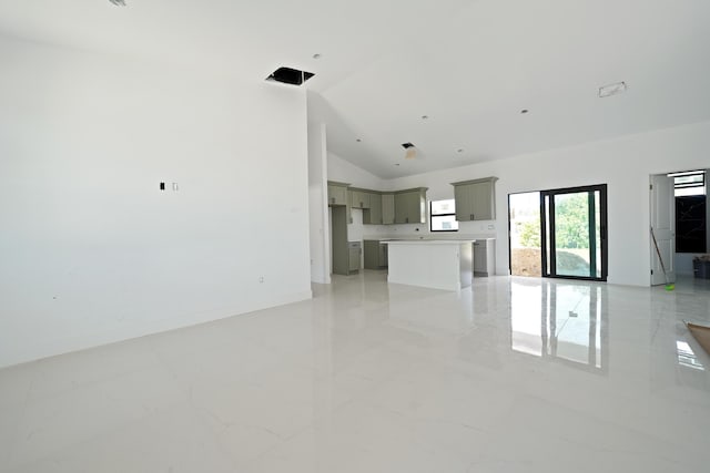 2458 NW 9th Ter, Cape Coral, FL 33993 - unfurnished living room featuring high vaulted ceiling, light marble finish floors, and baseboards
