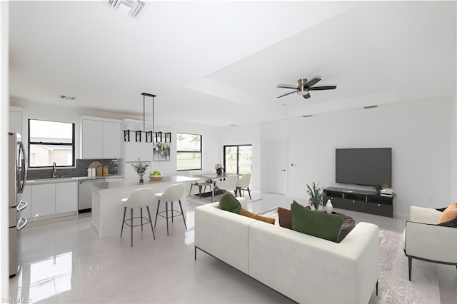 2458 NW 9th Ter, Cape Coral, FL 33993 - living room featuring healthy amount of natural light, a raised ceiling, and ceiling fan