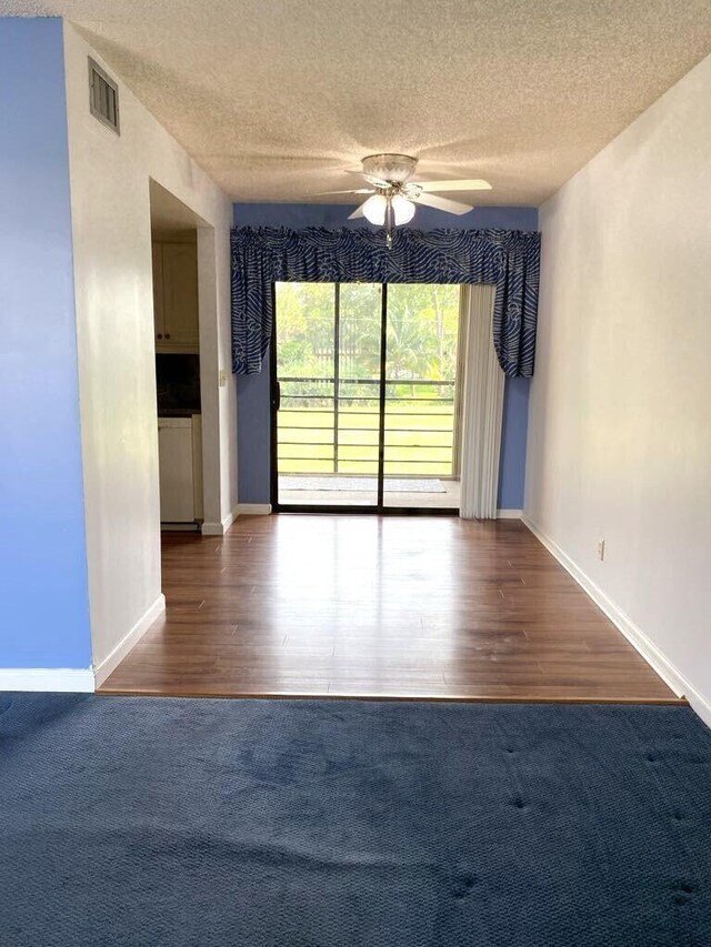 4273 Oak Terrace Dr, Greenacres, FL 33463 - spare room featuring a textured ceiling, a ceiling fan, baseboards, and wood finished floors