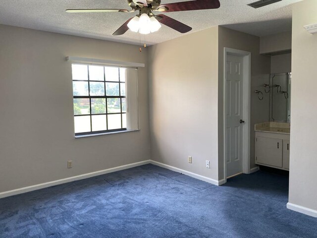 4273 Oak Terrace Dr, Greenacres, FL 33463 - unfurnished bedroom featuring dark carpet, a textured ceiling, baseboards, ensuite bath, and a ceiling fan