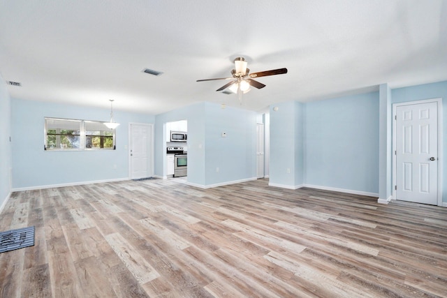 903 S 27th St, Fort Pierce, FL 34947 - unfurnished living room with a ceiling fan, light wood finished floors, and baseboards
