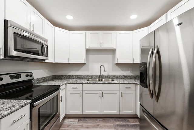 903 S 27th St, Fort Pierce, FL 34947 - kitchen with appliances with stainless steel finishes, a sink, white cabinetry, light wood-style floors, and recessed lighting