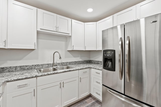 903 S 27th St, Fort Pierce, FL 34947 - kitchen featuring stainless steel fridge with ice dispenser, a sink, white cabinets, wood finished floors, and recessed lighting