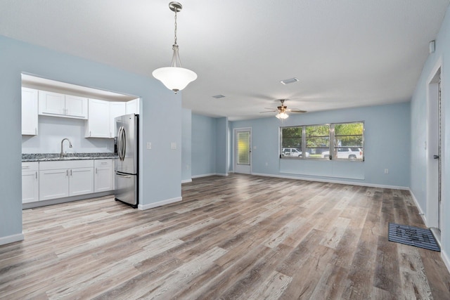 903 S 27th St, Fort Pierce, FL 34947 - unfurnished living room with a sink, light wood finished floors, a ceiling fan, and baseboards