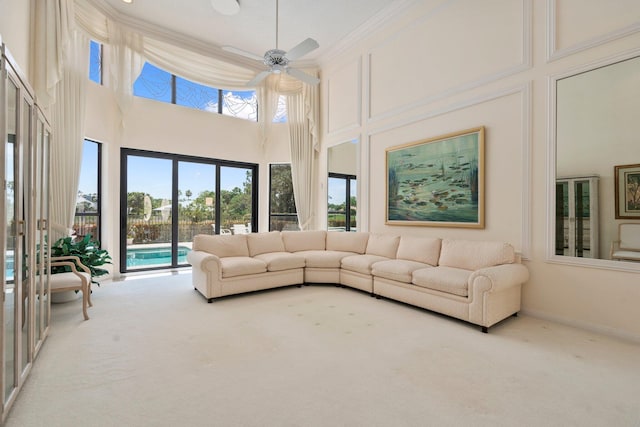 4402 SW Dundee Ct, Palm City, FL 34990 - living room featuring carpet, a high ceiling, a ceiling fan, and ornamental molding