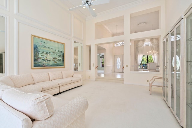 4402 SW Dundee Ct, Palm City, FL 34990 - living room with ornamental molding, a towering ceiling, a chandelier, carpet flooring, and ceiling fan