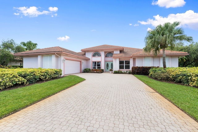 4402 SW Dundee Ct, Palm City, FL 34990 - mediterranean / spanish house with stucco siding, decorative driveway, a garage, and a tile roof