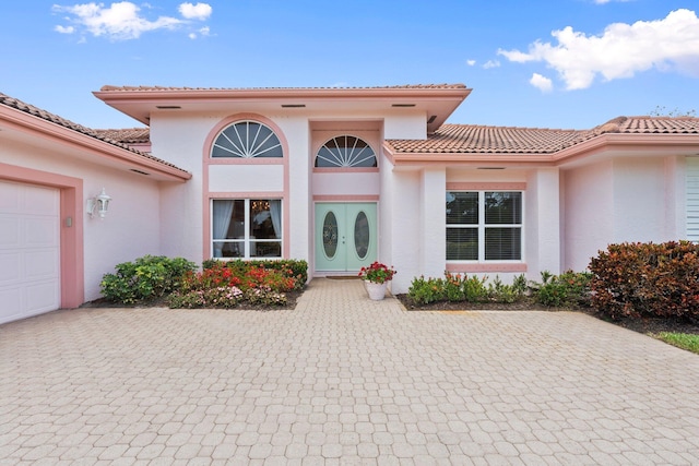 4402 SW Dundee Ct, Palm City, FL 34990 - doorway to property featuring stucco siding, a tiled roof, and a garage