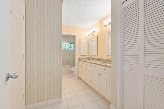 4402 SW Dundee Ct, Palm City, FL 34990 - bathroom with tile patterned flooring, double vanity, toilet, a closet, and a textured ceiling