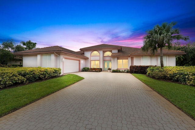 4402 SW Dundee Ct, Palm City, FL 34990 - mediterranean / spanish home with a garage, decorative driveway, a tiled roof, and stucco siding
