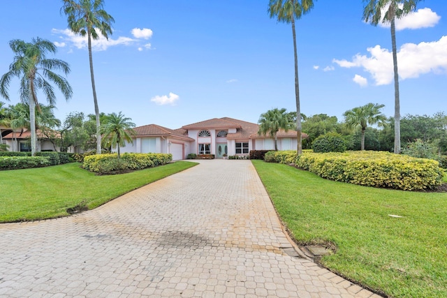 4402 SW Dundee Ct, Palm City, FL 34990 - mediterranean / spanish-style house with decorative driveway, an attached garage, a front yard, and stucco siding