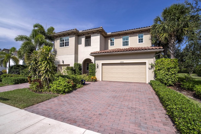 4858 Marginada Way, Lake Worth, FL 33467 - mediterranean / spanish-style house featuring decorative driveway, an attached garage, stucco siding, and a tiled roof