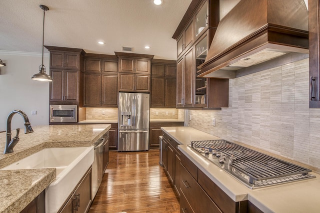 4858 Marginada Way, Lake Worth, FL 33467 - kitchen with stainless steel appliances, a sink, premium range hood, dark brown cabinets, and decorative light fixtures