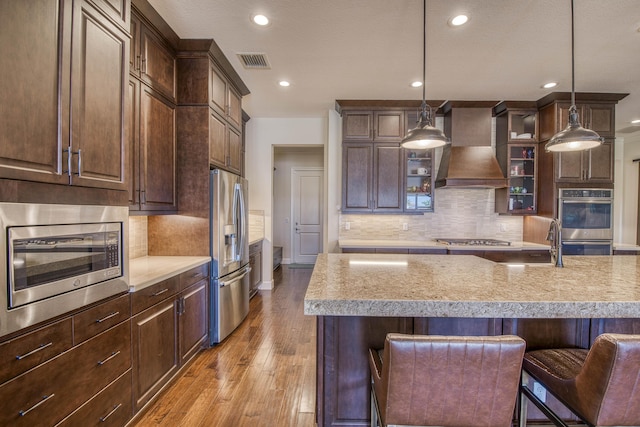 4858 Marginada Way, Lake Worth, FL 33467 - kitchen with stainless steel appliances, wall chimney exhaust hood, recessed lighting, light wood finished floors, and backsplash