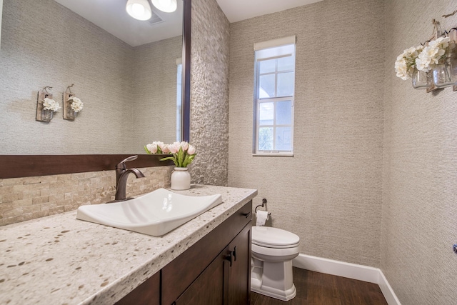 4858 Marginada Way, Lake Worth, FL 33467 - half bathroom with wood finished floors, vanity, toilet, baseboards, and decorative backsplash
