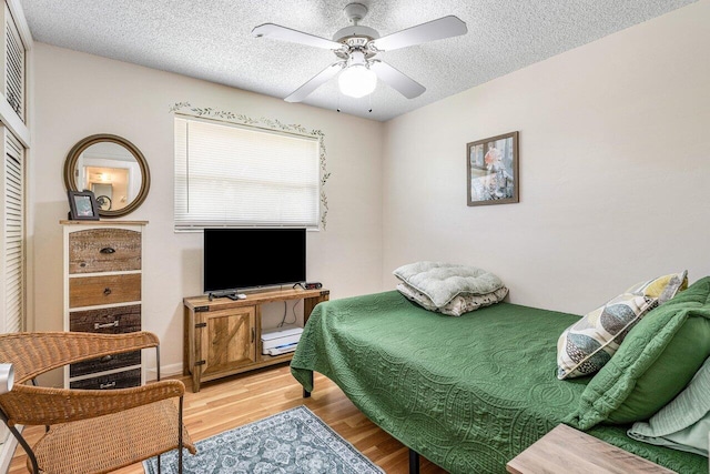4971 N Kay St, Palm Beach Gardens, FL 33418 - bedroom featuring light wood-type flooring, a textured ceiling, a ceiling fan, and a closet