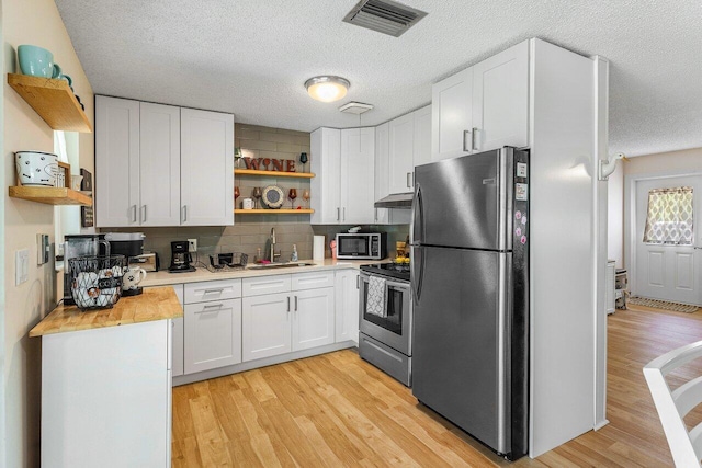 4971 N Kay St, Palm Beach Gardens, FL 33418 - kitchen featuring open shelves, stainless steel appliances, under cabinet range hood, a sink, and a textured ceiling