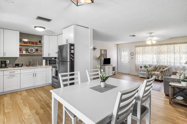 4971 N Kay St, Palm Beach Gardens, FL 33418 - dining space featuring light wood-style flooring, a ceiling fan, and a textured ceiling