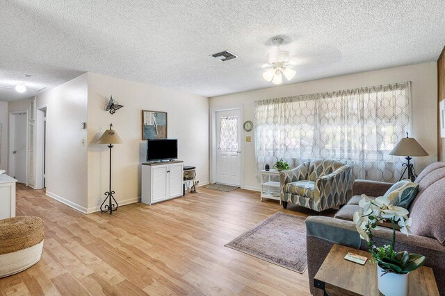 4971 N Kay St, Palm Beach Gardens, FL 33418 - living room featuring a textured ceiling, a ceiling fan, light wood-style flooring, and baseboards