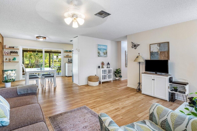 4971 N Kay St, Palm Beach Gardens, FL 33418 - living room featuring a ceiling fan, light wood-style flooring, and a textured ceiling