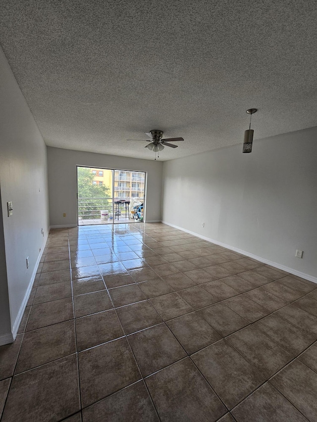 2800 NW 56th Ave Unit C306, Lauderhill, FL 33313 - empty room with a ceiling fan, a textured ceiling, baseboards, and dark tile patterned flooring