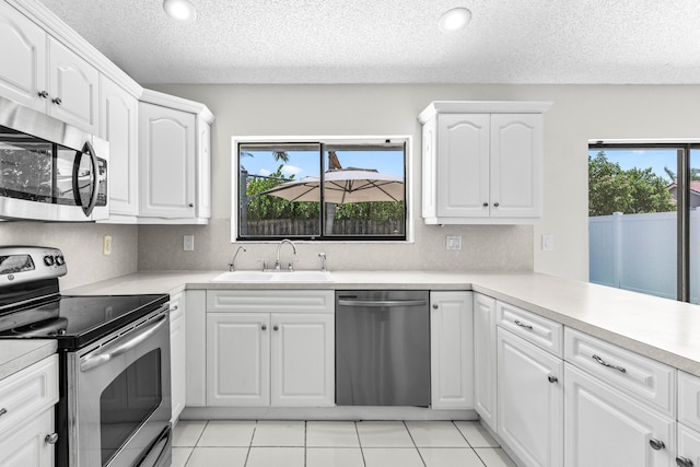 9496 Majestic Way, Boynton Beach, FL 33437 - kitchen with appliances with stainless steel finishes, a sink, a textured ceiling, white cabinets, and light countertops
