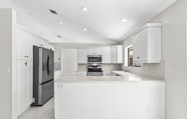 9496 Majestic Way, Boynton Beach, FL 33437 - kitchen with stainless steel appliances, a peninsula, light countertops, a textured ceiling, and white cabinetry
