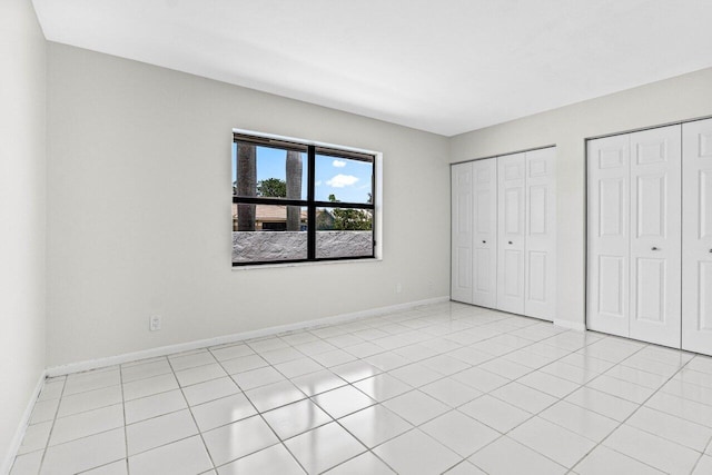 9496 Majestic Way, Boynton Beach, FL 33437 - unfurnished bedroom with multiple closets, baseboards, and light tile patterned floors