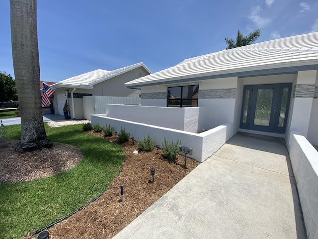 9496 Majestic Way, Boynton Beach, FL 33437 - view of exterior entry with stucco siding, stone siding, and a tile roof