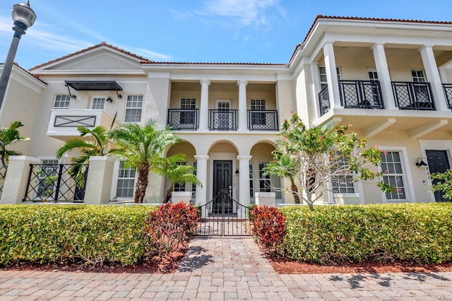 850 NW 83rd Ln, Boca Raton, FL 33487 - neoclassical home featuring stucco siding, a balcony, a gate, and a tile roof