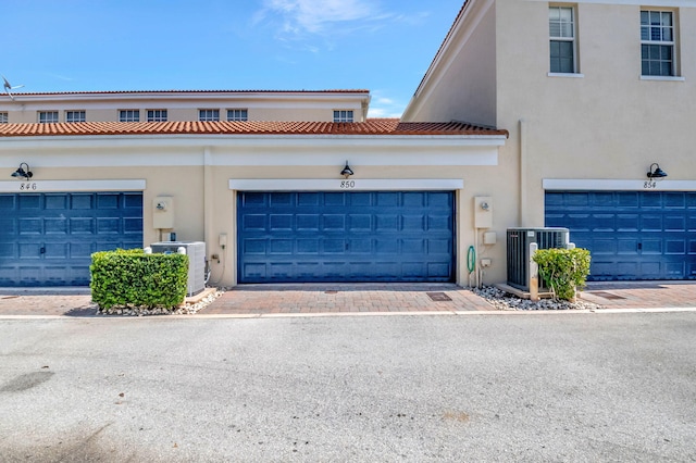 850 NW 83rd Ln, Boca Raton, FL 33487 - view of front of house with cooling unit, stucco siding, and a garage
