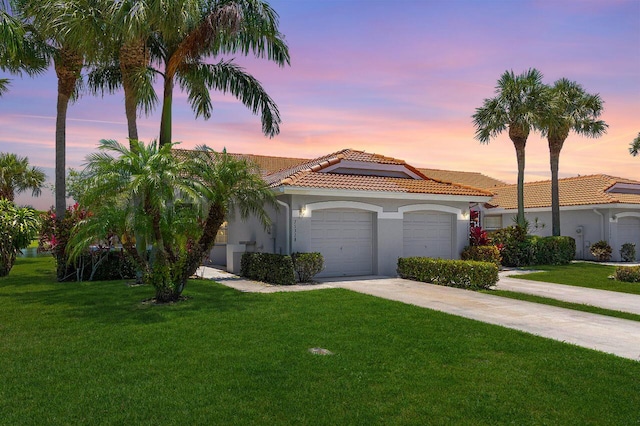 15318 W Tranquility Lake Dr, Delray Beach, FL 33446 - mediterranean / spanish-style home with a tile roof, a yard, stucco siding, and an attached garage