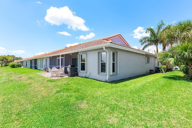 15318 W Tranquility Lake Dr, Delray Beach, FL 33446 - rear view of house with a patio, stucco siding, a lawn, and a tiled roof