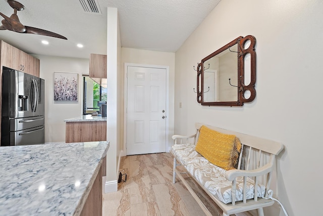 6860 SE Constitution Blvd Unit 204, Hobe Sound, FL 33455 - kitchen with stainless steel fridge with ice dispenser, light stone countertops, a ceiling fan, recessed lighting, and baseboards