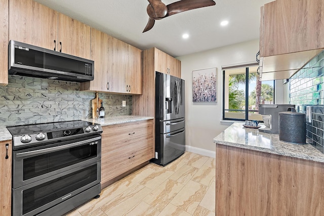 6860 SE Constitution Blvd Unit 204, Hobe Sound, FL 33455 - kitchen with stainless steel appliances, baseboards, a ceiling fan, light brown cabinets, and light stone counters