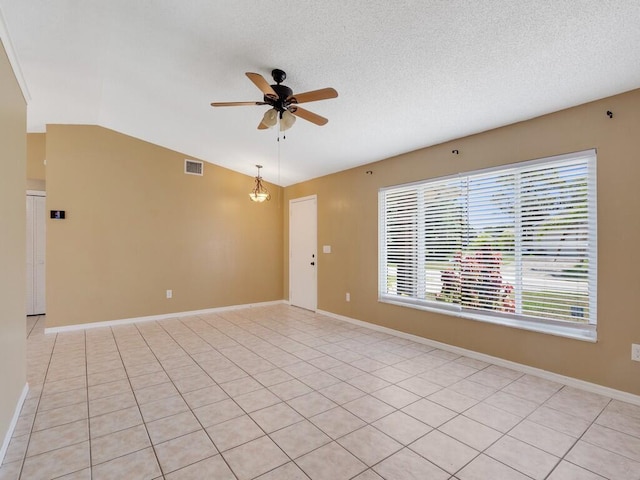 1030 Locust Ave NW, Palm Bay, FL 32907 - spare room with a ceiling fan, vaulted ceiling, light tile patterned floors, baseboards, and a textured ceiling