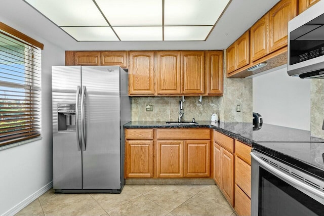 9880 Marina Blvd Unit 1504, Boca Raton, FL 33428 - kitchen featuring appliances with stainless steel finishes, a sink, light tile patterned flooring, brown cabinets, and backsplash