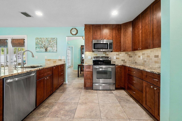 1858 Bartlett Ct, Lake Clarke Shores, FL 33406 - kitchen featuring appliances with stainless steel finishes, a sink, tasteful backsplash, light stone countertops, and recessed lighting