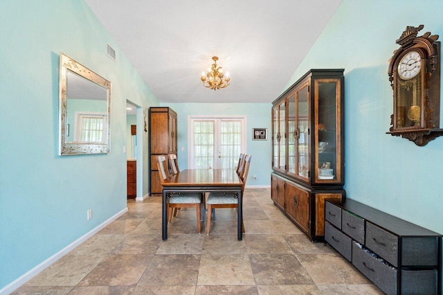 1858 Bartlett Ct, Lake Clarke Shores, FL 33406 - dining room featuring a chandelier, baseboards, lofted ceiling, and stone finish flooring
