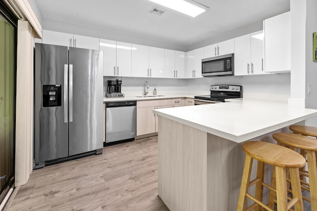 5135 Mirror Lakes Blvd, Boynton Beach, FL 33472 - kitchen with appliances with stainless steel finishes, light wood-style floors, a peninsula, a sink, and light countertops